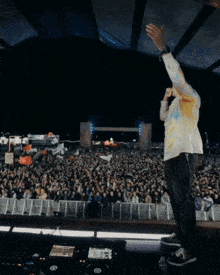a man stands in front of a crowd of people at a concert