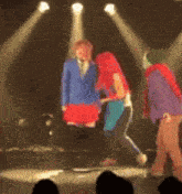 a group of people are standing on a stage with spotlights shining on them