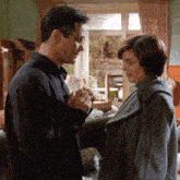 a man and a woman are looking at each other
