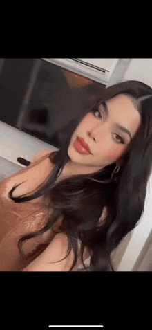 a woman with long black hair is taking a selfie with her phone .