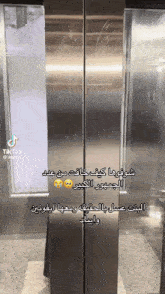 a stainless steel elevator with arabic writing on the door