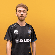 a man is wearing a black shirt that says aldi
