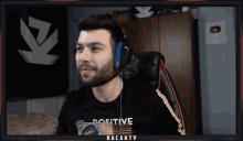 a man wearing headphones and a black shirt that says positive