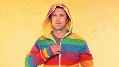 a man is wearing a rainbow striped hoodie with a hood