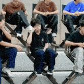 a group of young men are sitting in wooden director 's chairs .