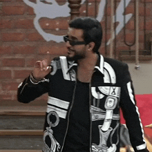 a man wearing sunglasses and a black and white jacket with a skull on it