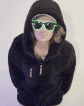 a man wearing sunglasses and a hooded jacket with a zipper
