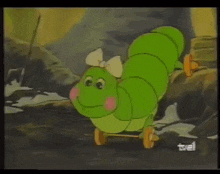 a cartoon of a green caterpillar with wheels and a bow
