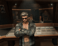 a shirtless man with his arms crossed stands in front of a sound board
