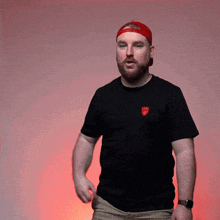 a man with a beard wears a black shirt with a rolling stones logo on the front