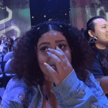 a woman with a ring on her finger covering her face