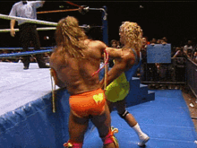 two wrestlers are fighting in a ring with a sign in the background that says ' wrestling ' on it