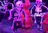 a group of people in skeleton costumes are dancing on a stage .