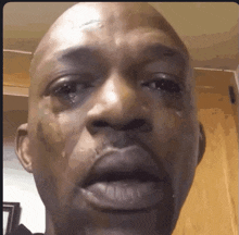 a bald man is crying with tears running down his face