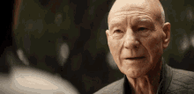 a close up of a bald man 's face with a blurred background