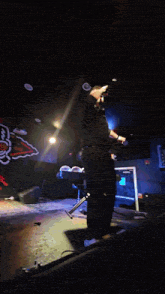 a man singing into a microphone on a stage in front of a wall that has a bull on it