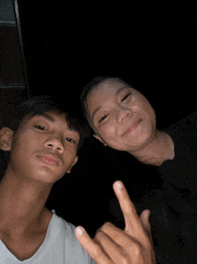 a man and a woman are posing for a picture and the woman is giving the middle finger