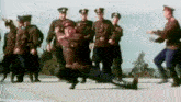 a group of soldiers are dancing in a line on a street .