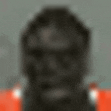 a blurry picture of a man 's face with a red shirt on