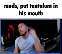 a man is sitting in front of a screen with the words `` mods , put tantalum in his mouth '' .