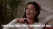a woman is sitting on a couch and saying `` i did not see that coming at all ''
