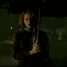 a woman is holding an umbrella in the dark