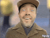 a man wearing a hat and a coat is smiling with a gif jif sticker