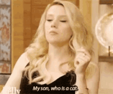 a woman in a black dress is talking about her son , who is a cat .