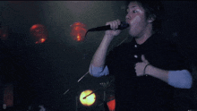 a man singing into a microphone with the letter d in the lower right corner