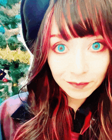 a woman with blue eyes and red hair looks at the camera