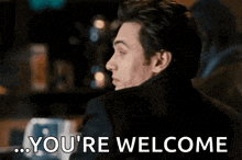 a man is smiling and says `` you 're welcome '' while looking at the camera .