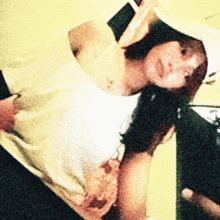 a blurry picture of a woman wearing a white tank top