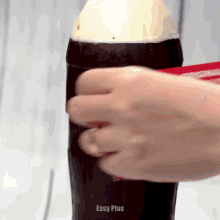 a person is opening a coca cola bottle with the words easy plus written on the bottom