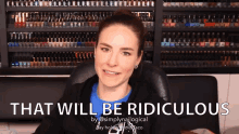 a woman is sitting in front of a shelf of nail polish and says that will be ridiculous