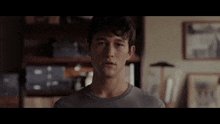 a man in a grey shirt is standing in a room