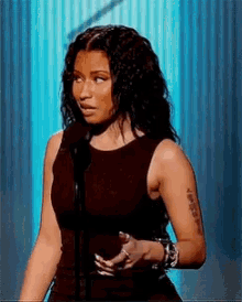 a woman with a tattoo on her arm is wearing a black tank top