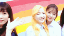 a group of young girls are posing for a picture in front of a rainbow wall