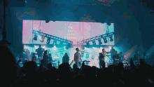 a group of people singing in front of a large screen which says i 'm not good enough