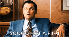 a man in a suit and tie is sitting on a couch and saying " soooo hot a.f. "