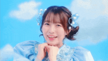 a girl wearing a blue dress and pearls in her hair