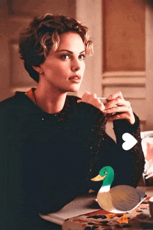 a woman sitting at a table holding a cup of coffee