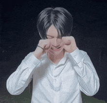 a young man in a white shirt is crying