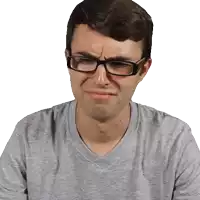 a man wearing glasses making a sad face