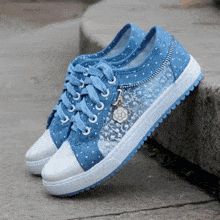 a pair of blue and white shoes with a flower on the side of them