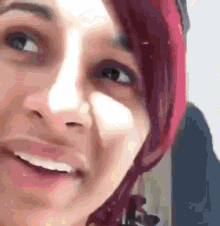 a close up of a woman 's face with red hair and a pink hat .