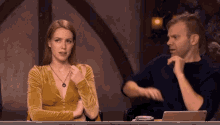 a man and a woman are sitting at a table with a laptop on it