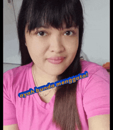 a woman wearing a pink shirt has ayah bunda menggatol written on her shirt