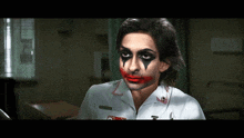 a woman in a nurse 's uniform has joker makeup on her face