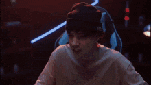 a man wearing a beanie and a t-shirt with a joker on it is playing a game