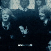 a group of people are standing in a dark room and the words moonyvfxaep are on the bottom right